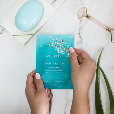 FACTORFIVE's Growth Factor Post Treatment Mask being shown in inviting home setting, with other wellness accessories, facial roller, gua sha