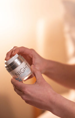A female holding FACTORFIVE's Night Retinol Cream at night